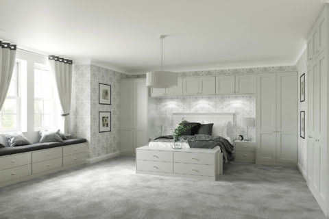 Classic styled bedroom with built in cupboard surrounding the bed. With drawers at the end of the bed. All painted light grey.