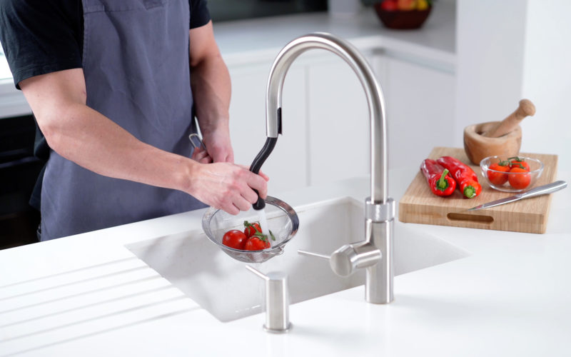 Quooker hot tap showing extendable tap washing tomatoes