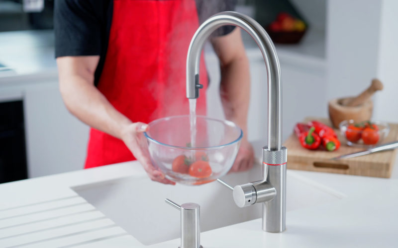 Quooker hot tap showing hot wat being poured straight from the tap into a bowl of tomatoes