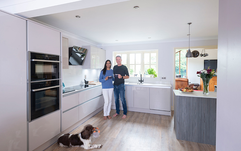 Mr and Mrs Francis standing in their new neutral handeless kitchen installed by the KBB Centre