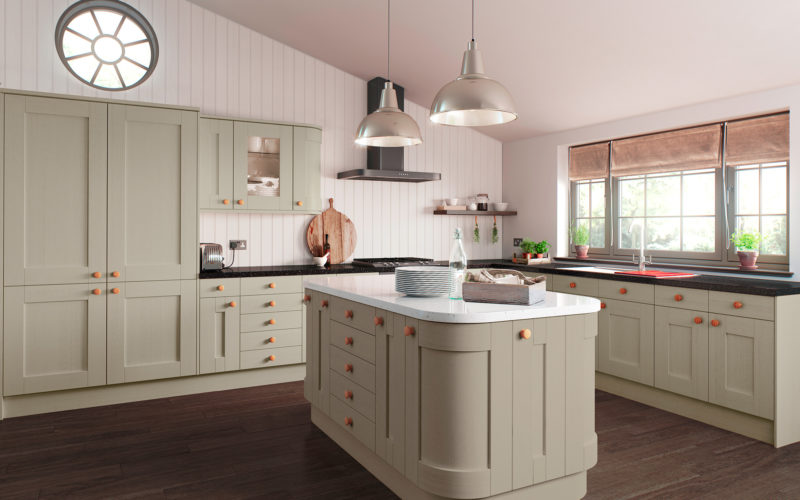 Classic light olive green kitchen with matching island. The unit around the walls have a black countertop but the island has a textured white counter top. All cabinets have a shaker style door.