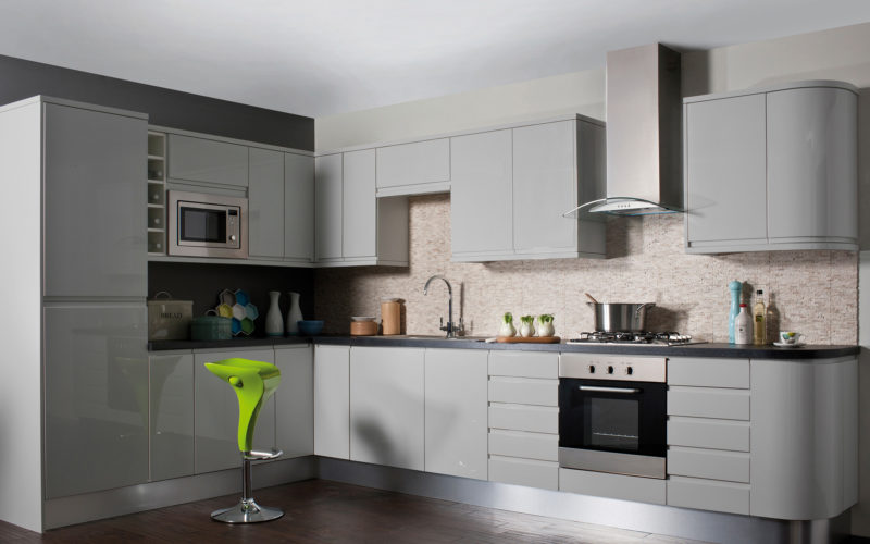 Grey gloss kitchen cabinets and integrated fridge freezer. With a textured tile background and dark grey counter tops.