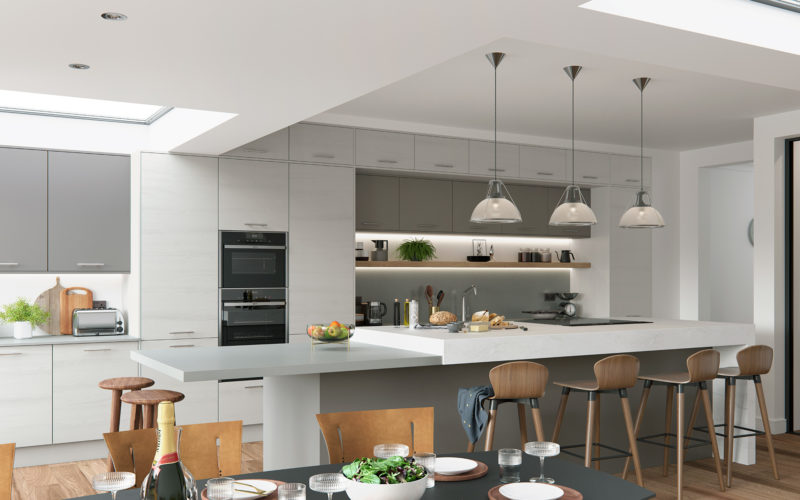 Modern large kitchen with white and grey cupboards. Kitchen island with breakfast bar, all in very light grey with white counter top.