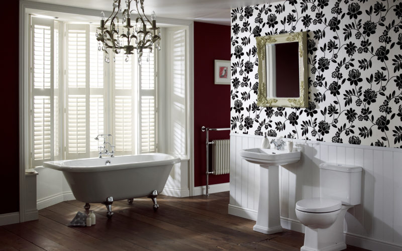 Hampshire Suite - white sink, toilet and freestanding bath on silver modern legs in a red with black and white floral wallpaper room