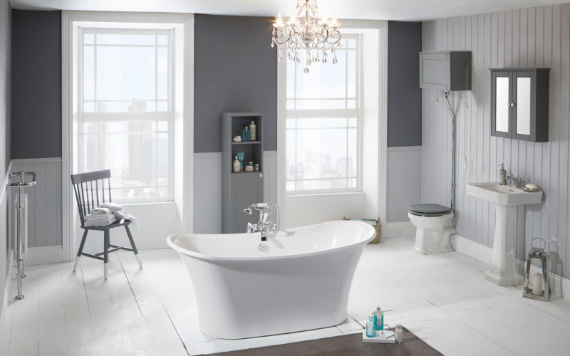 An airy bathroom showroom in Ipswich that features a large white spa freestanding bathtub in the middle, with grey and white walls and large windows