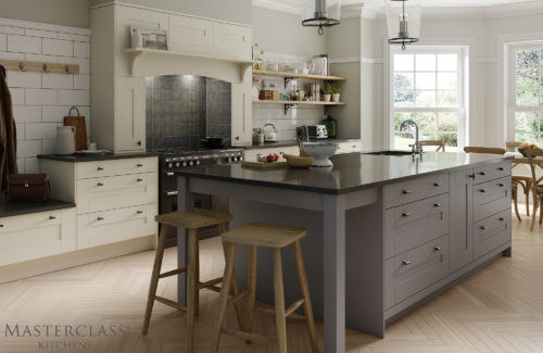 Large grey island with black countertop in an ivory cupboard kitchen